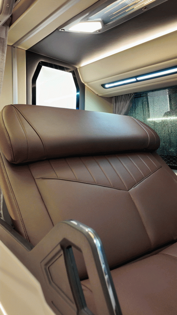 Bicol Isarog’s Ultimate Sleeper Bus, with an upper bunk bed sitting up and privacy curtains drawn open.